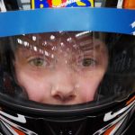 Enfant équipé d'un casque de karting bleu blanc noir avec visière teintée