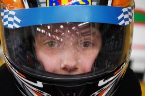 Enfant équipé d'un casque de karting bleu blanc noir avec visière teintée