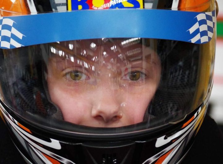 Enfant équipé d'un casque de karting bleu blanc noir avec visière teintée