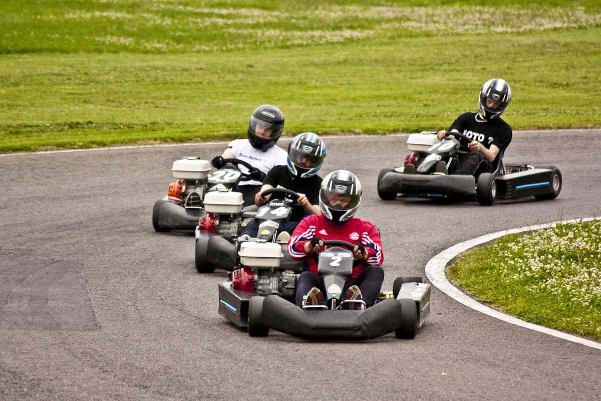 Quatre conducteurs en karting tournent sur un virage de circuit