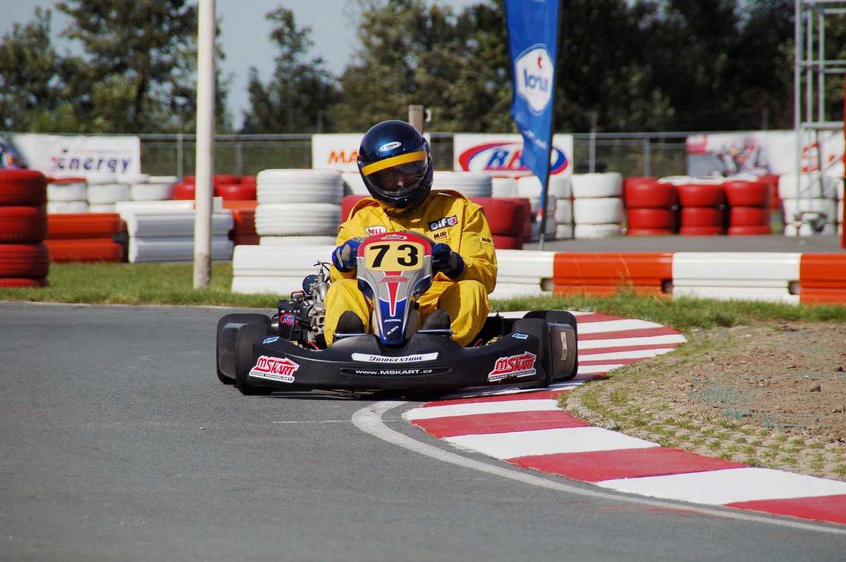 Un coureur en kart jaune 73 tourne sur virage du circuit Un coureur en kart jaune 73 tourne sur virage du circuit