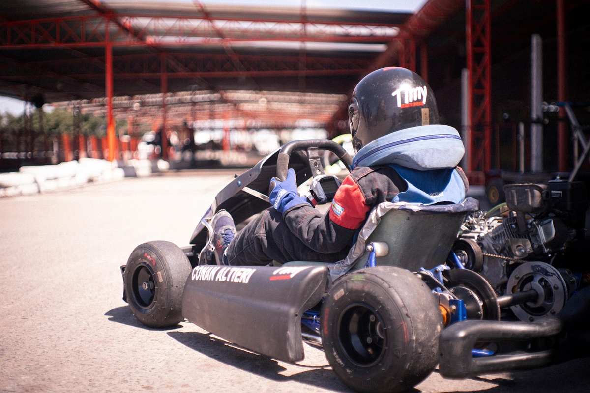 Un conducteur en karting porte un casque noir et conduit Un conducteur en karting porte un casque noir et conduit