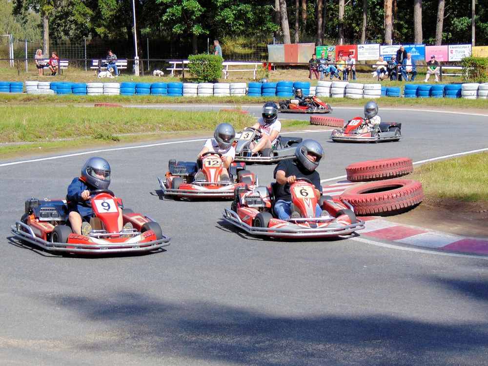Des enfants pilotent des karting sur un circuit en plein air Des enfants pilotent des karting sur un circuit en plein air