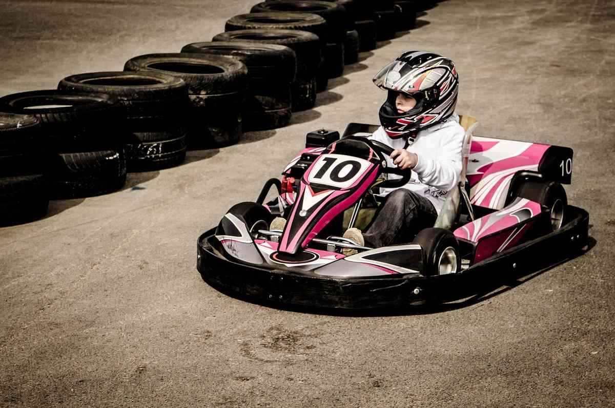 Pilote en kart sur circuit, numéroté 10, casque, pneus de sécurité Pilote en kart sur circuit, numéroté 10, casque, pneus de sécurité