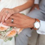 Mains tenant un bouquet, alliance et montre au poignet