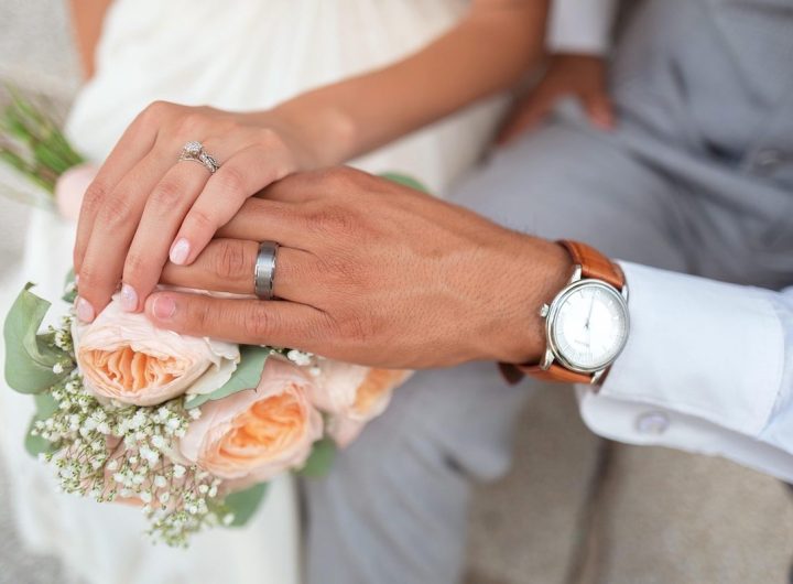 Mains tenant un bouquet, alliance et montre au poignet