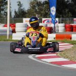 Un coureur en kart jaune 73 navigue sur virage de circuit