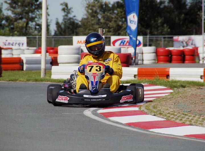 Un coureur en kart jaune 73 navigue sur virage de circuit